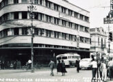 Detalhe de cartão postal de Juiz de Fora mostrando um ônibus rodoviário Caio diante do prédio da Caixa Econômica Federal na cidade mineira (fonte: Ivonaldo Holanda de Almeida).