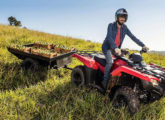 Quadriciclo Honda tracionando reboque em atividade rural.