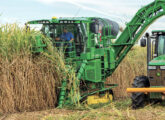 Ao lado de um trator John Deere, a colhedora CH950 em ação.