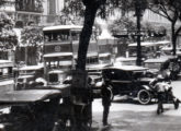 Ônibus de dois andares da Excelsior detido em engarrafamento na avenida Rio Branco, Rio de Janeiro (RJ), no final da década de 20; a fotografia mostra um detalhe de cartão postal.