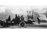16 de novembro de 1907: Santos-Dumont transportando seu primeiro avião Demoiselle em um automóvel Renault por ele adaptado.