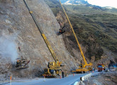 À frente, guindaste hidráulico 22VG (22 t), com lança de 20 m e cabine acoplada à lança giratória, operando no Peru (fonte: site inversionessantarosa). 