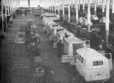 Linha de acabamentos da Kombi; em ambos os lados vê-se Fuscas de modelo antigo, ainda importados, em processo de montagem (o sedã só seria nacionalizado em 1959) (foto: Automóveis & Acessórios).